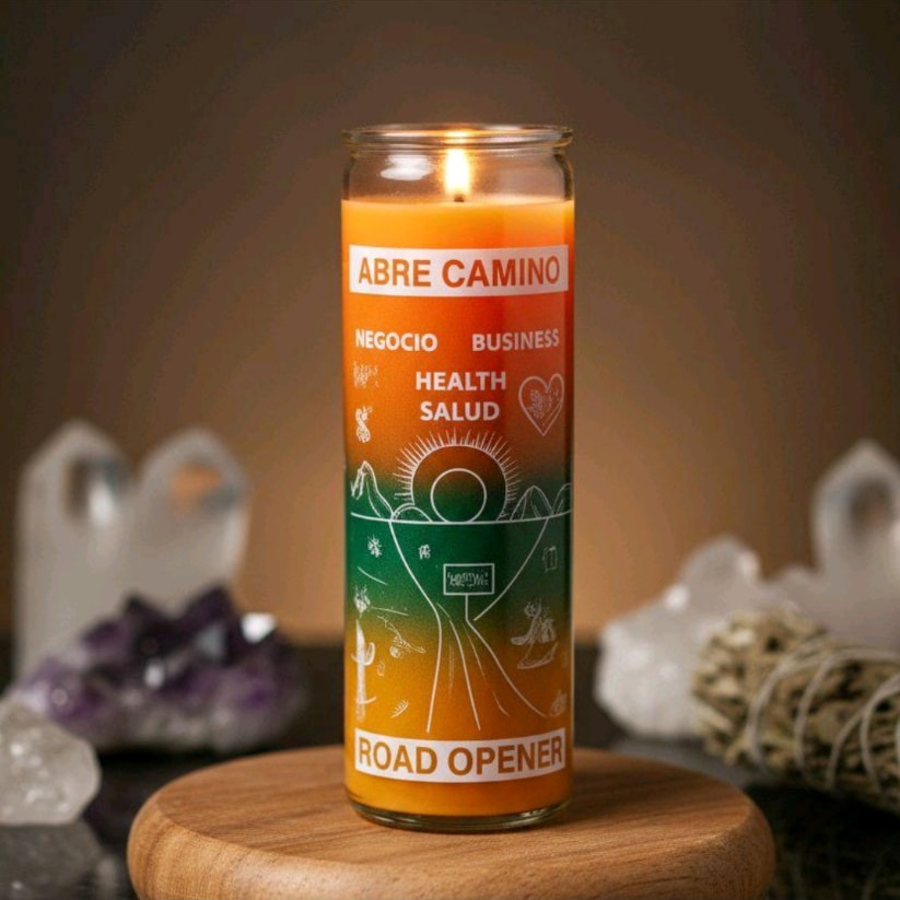 Veladora Abre Camino Road Opener encendida en vaso de vidrio naranja y verde junto a cuarzos