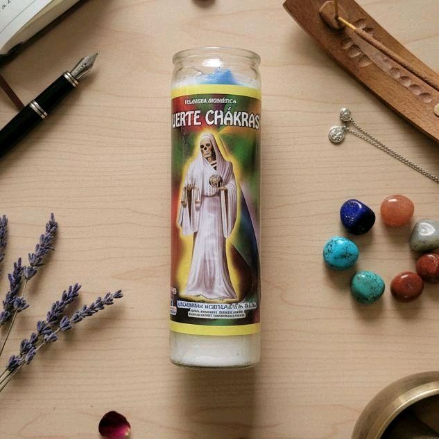 Veladora Muerte Chákras multicolor de siete días con cuarzos, lavanda e incienso sobre mesa de madera clara