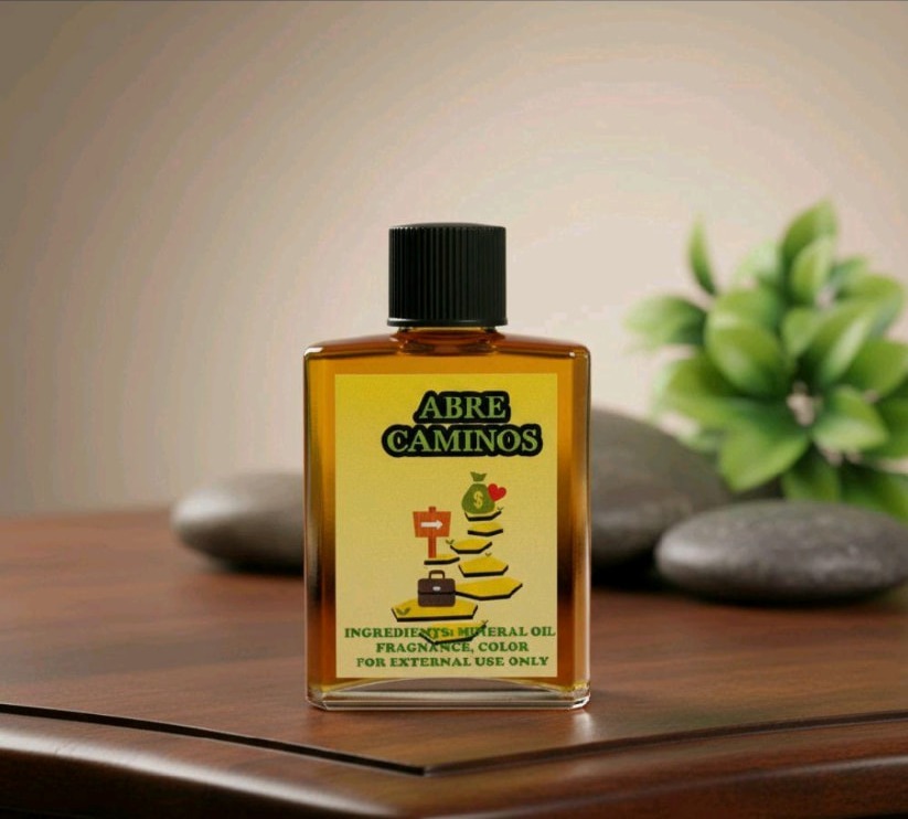 Frasco de Aceite Espiritual Abre Caminos de 1 oz con etiqueta dorada sobre mesa de madera